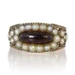 An antique Georgian garnet and seed pearl ring in high carat yellow gold set with an elongated