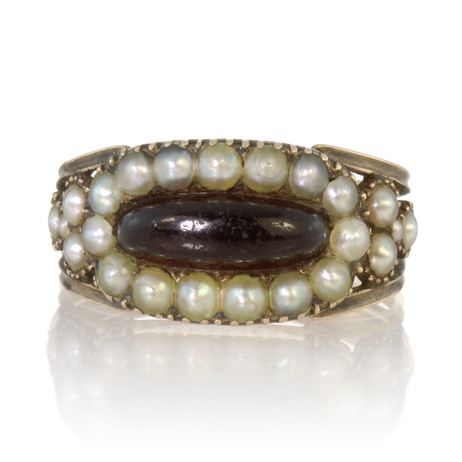 An antique Georgian garnet and seed pearl ring in high carat yellow gold set with an elongated