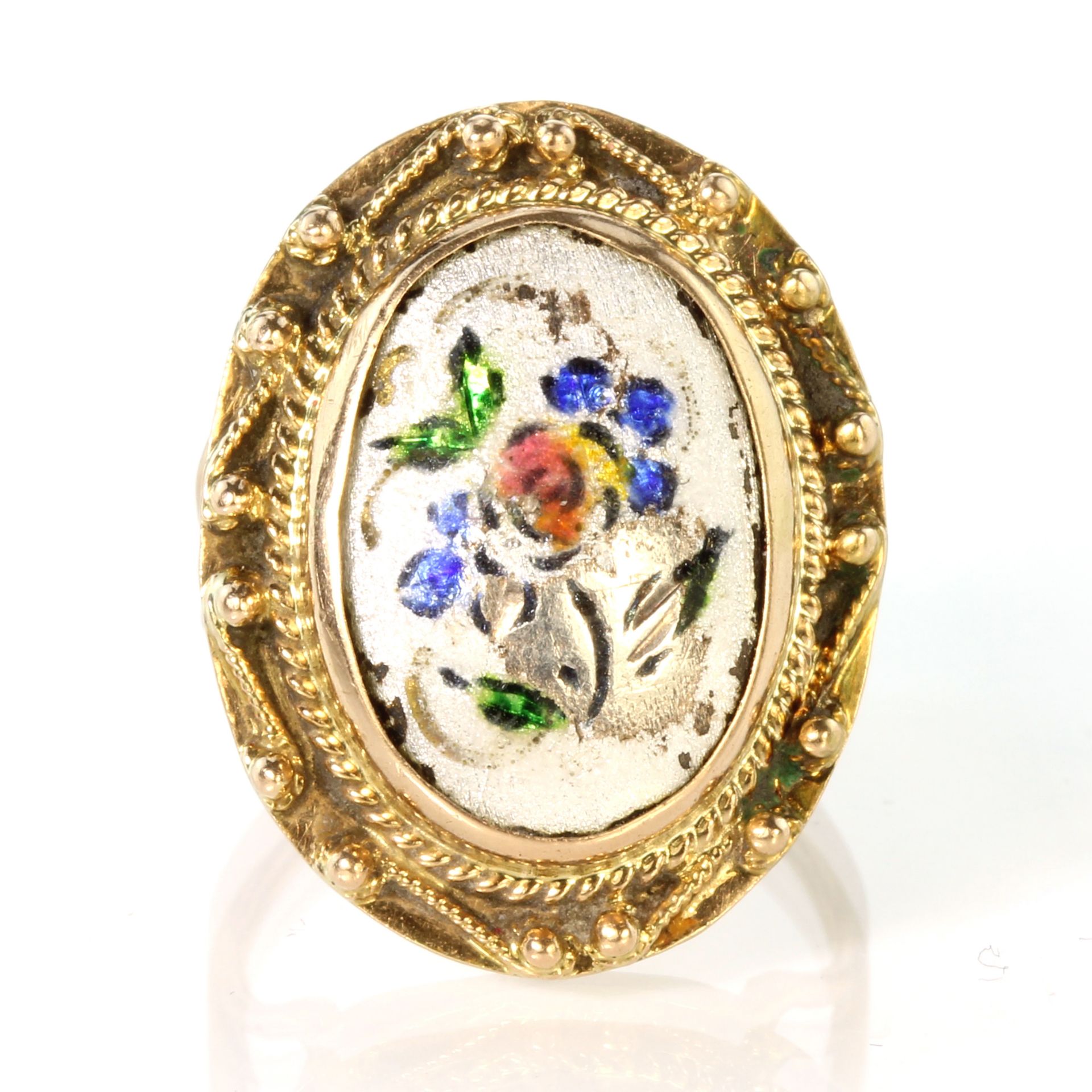 An antique Victorian enamel ring in 15ct yellow gold set with an oval enamelled panel featuring a