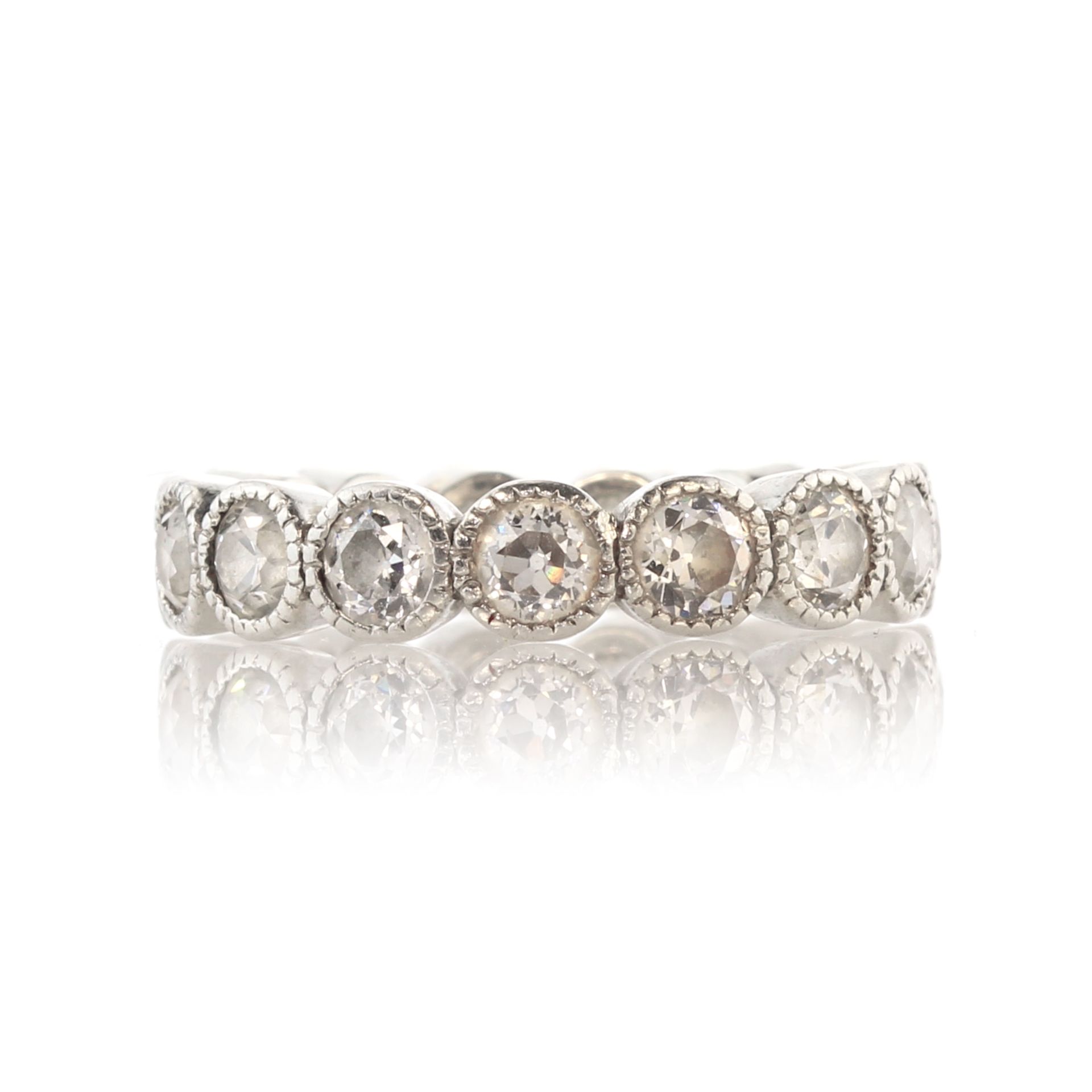 An antique diamond eternity ring in white gold or platinum set with fifteen old round cut diamonds