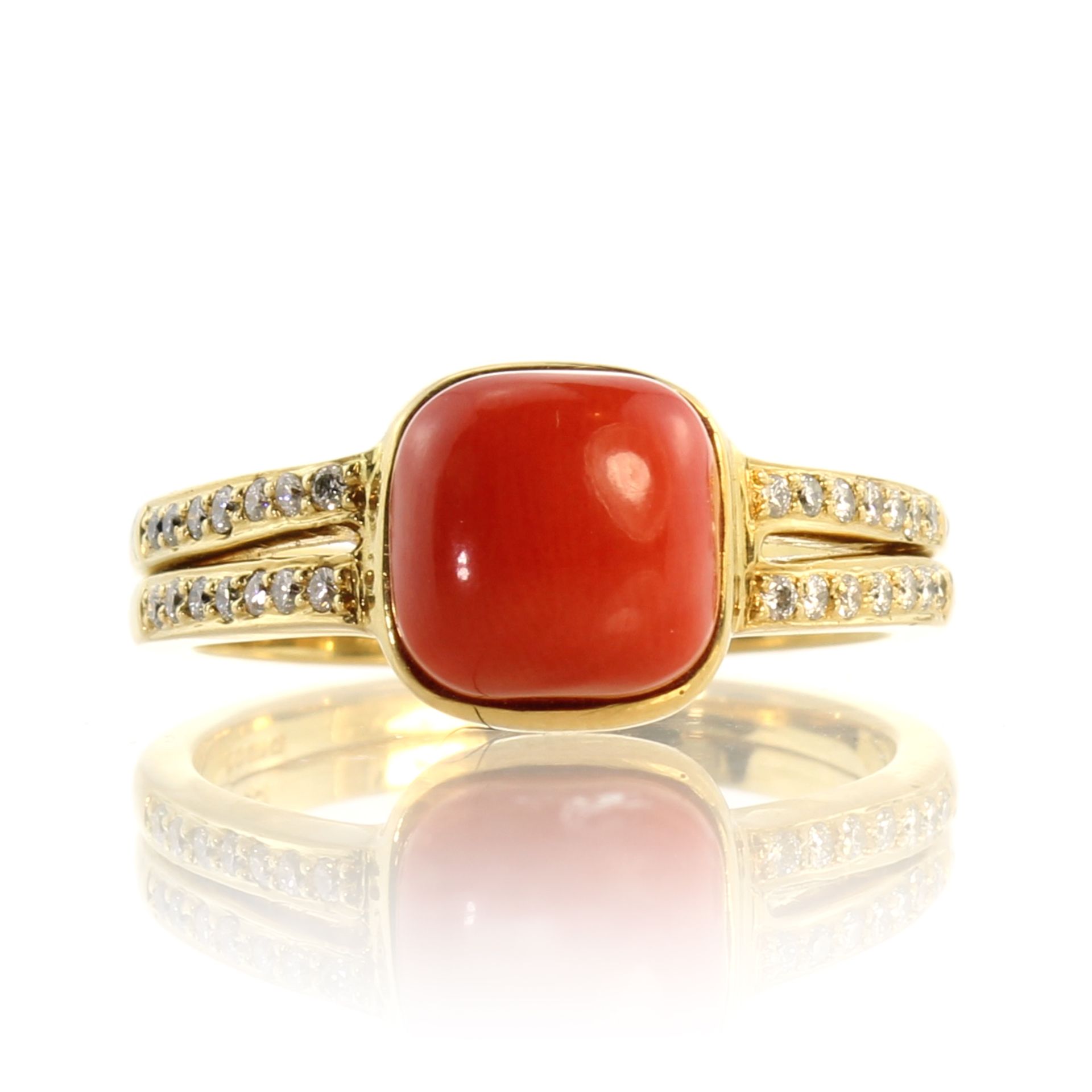 A coral and diamond dress ring in 18ct yellow gold set with a central square coral cabochon