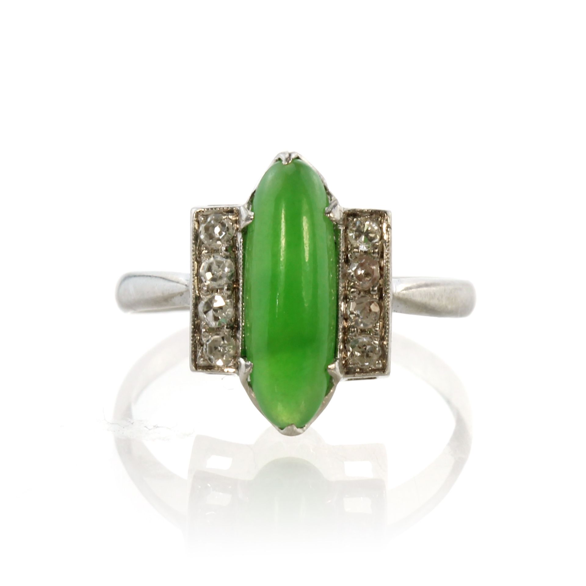 A jade and diamond dress ring in white gold or platinum set with a central elongated oval cabochon