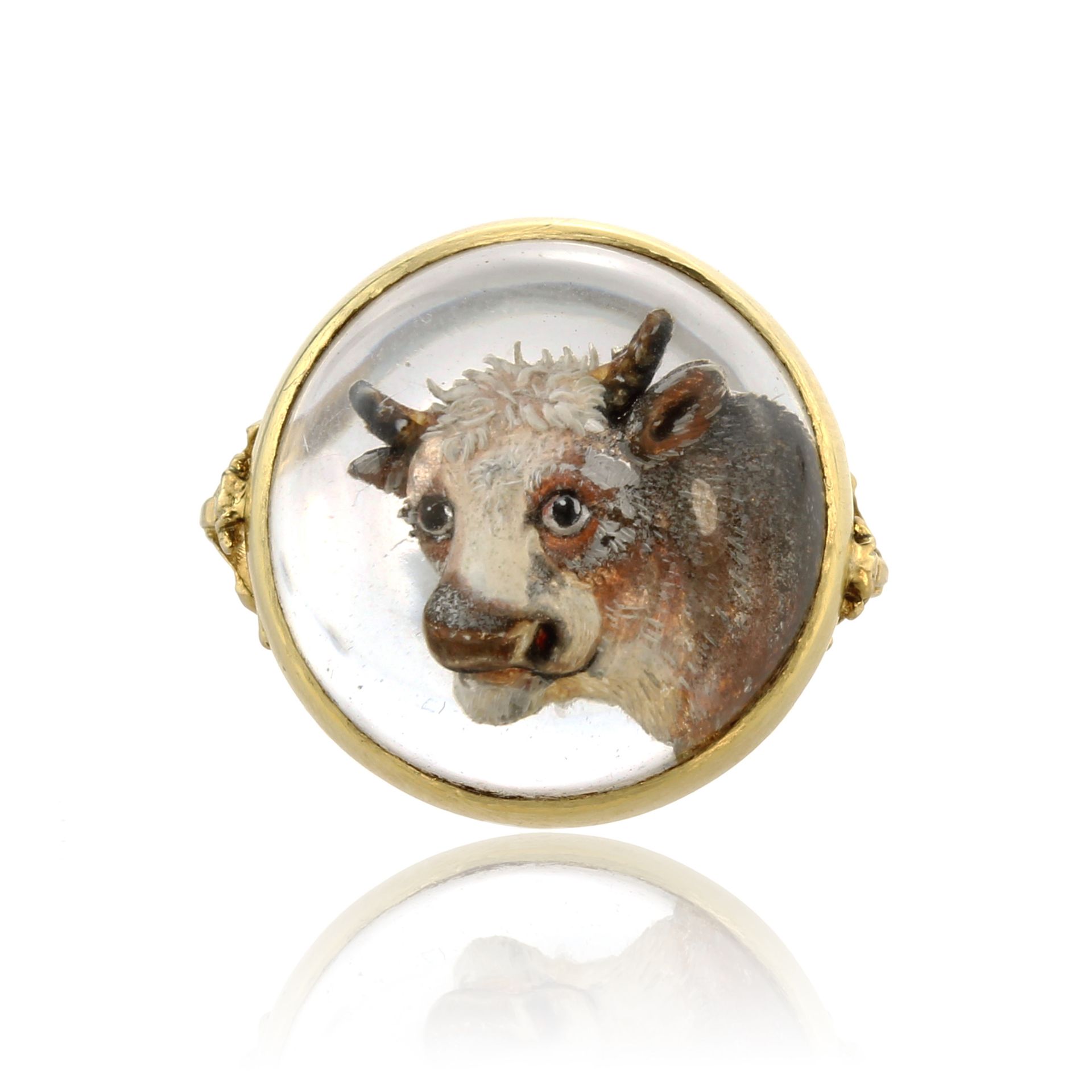 An antique Essex crystal / reverse intaglio cow ring in yellow gold set with a central circular