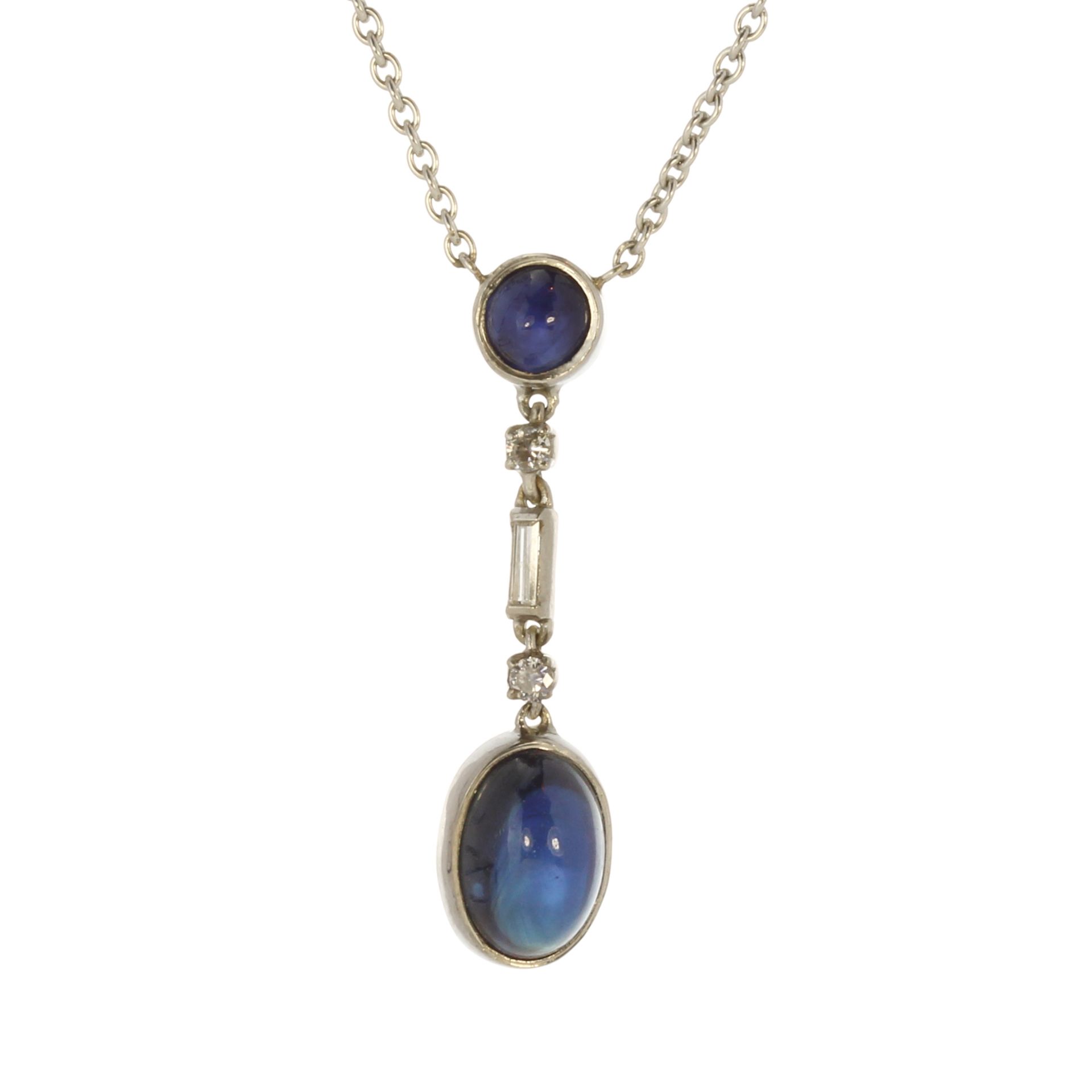 A sapphire and diamond necklace in white gold or platinum set with a large, oval cabochon blue