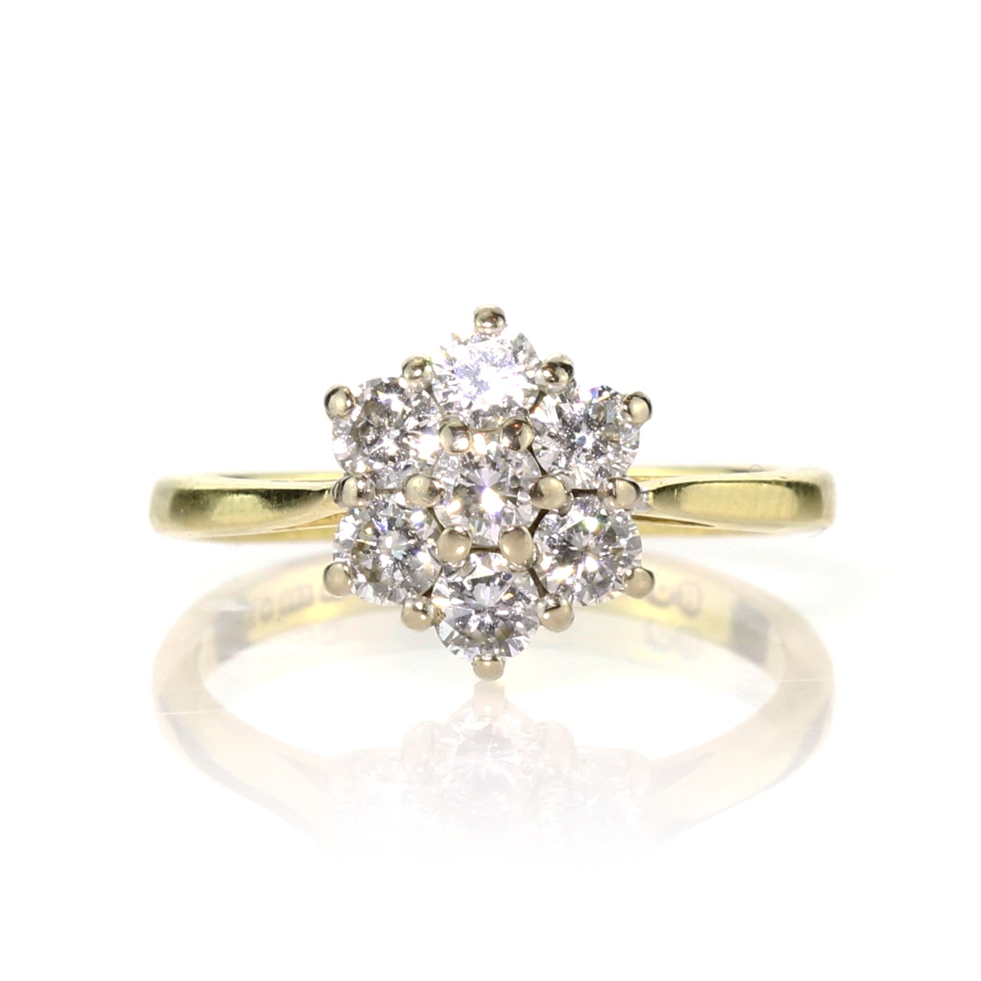 A diamond cluster dress ring in 18ct yellow gold set with seven round cut diamonds in a flower