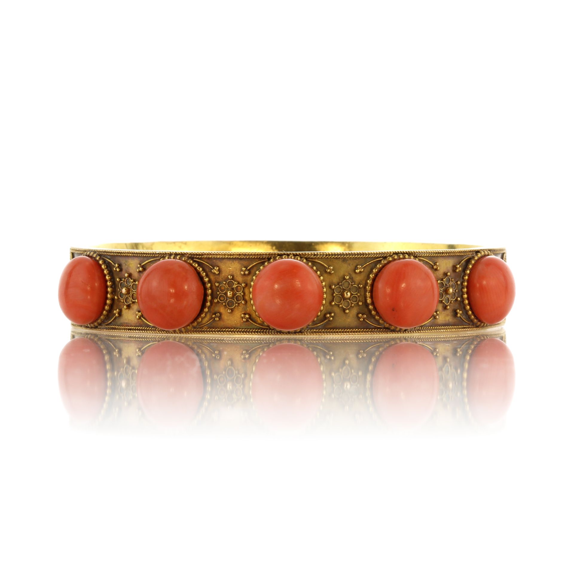 An antique coral bangle in 15ct yellow gold circa 1875, designed as a plain band set with five large