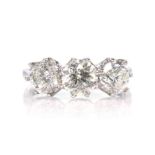 A diamond three stone dress ring in 18ct white gold set with three graduated round cut diamonds,