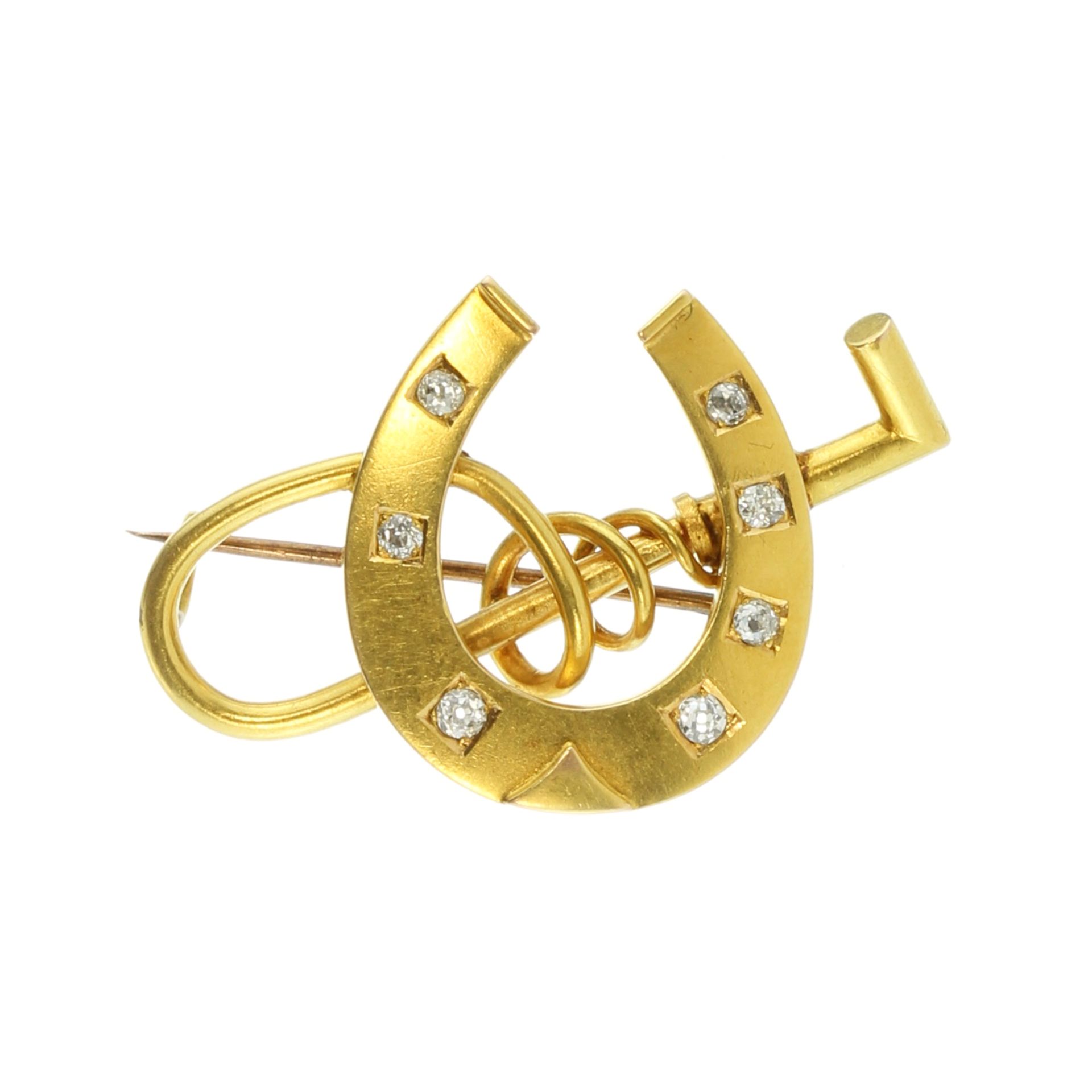 An antique novelty jewelled diamond racing brooch in high carat yellow gold designed as a horse shoe