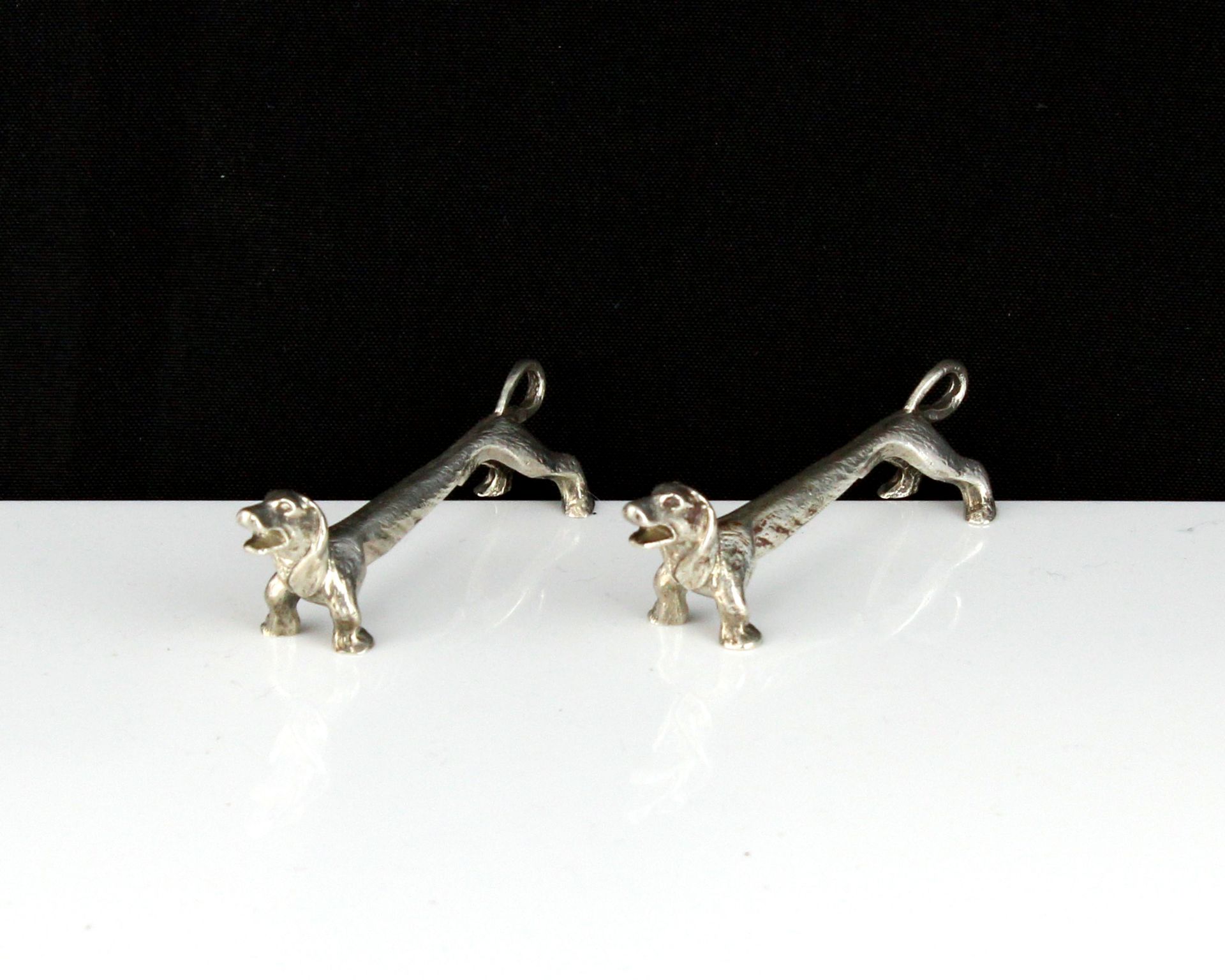 A pair of antique George V Sterling Silver sausage dog knife rests by Roberts & Dore Ltd,