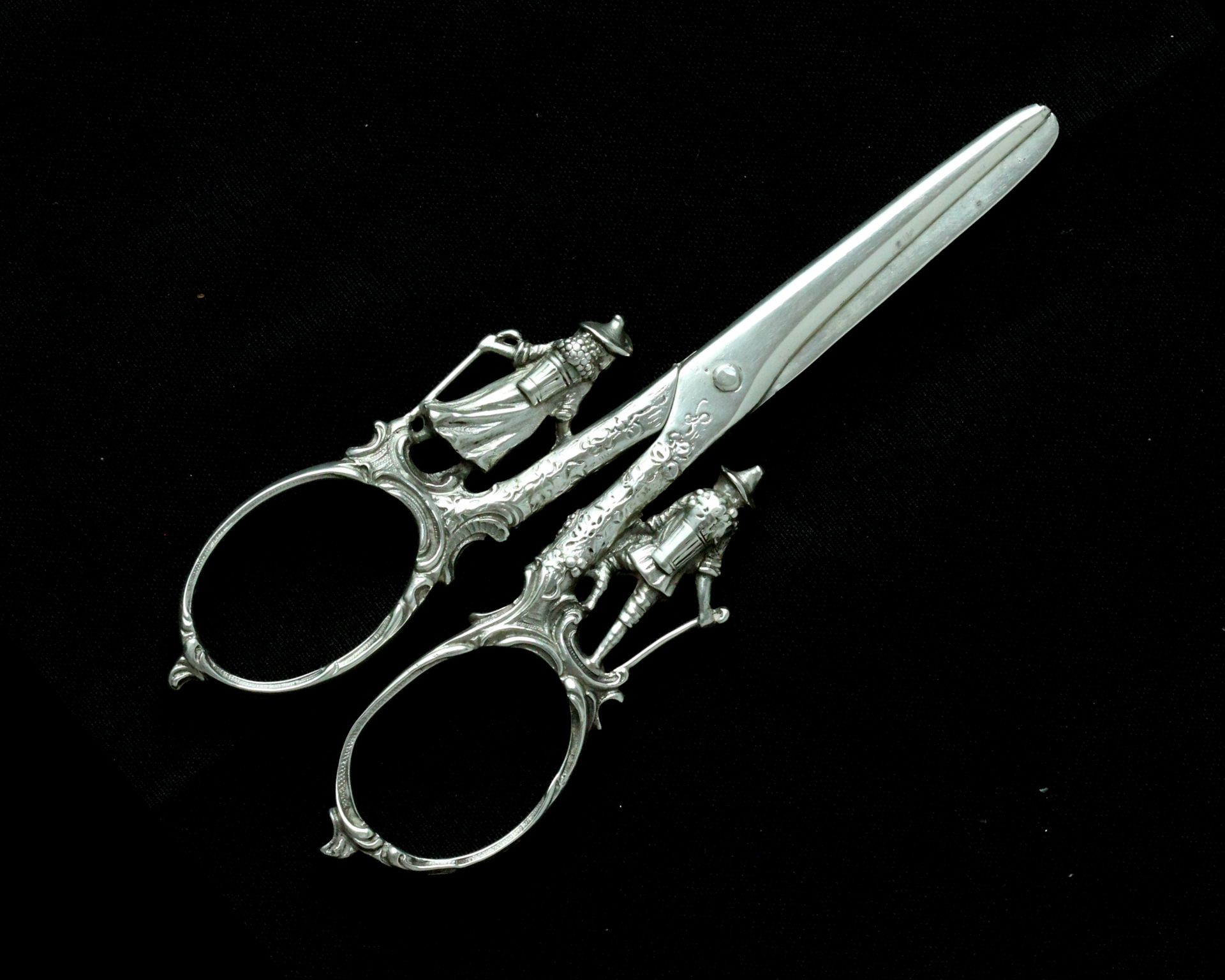 A pair of antique continental silver grape scissors with figural decoration to the handles,