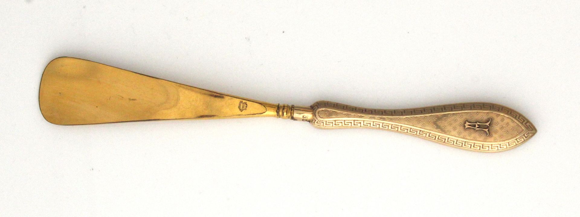 An antique 9ct yellow gold shoe horn by Mappin & Webb, the gold handle with finely engine turned