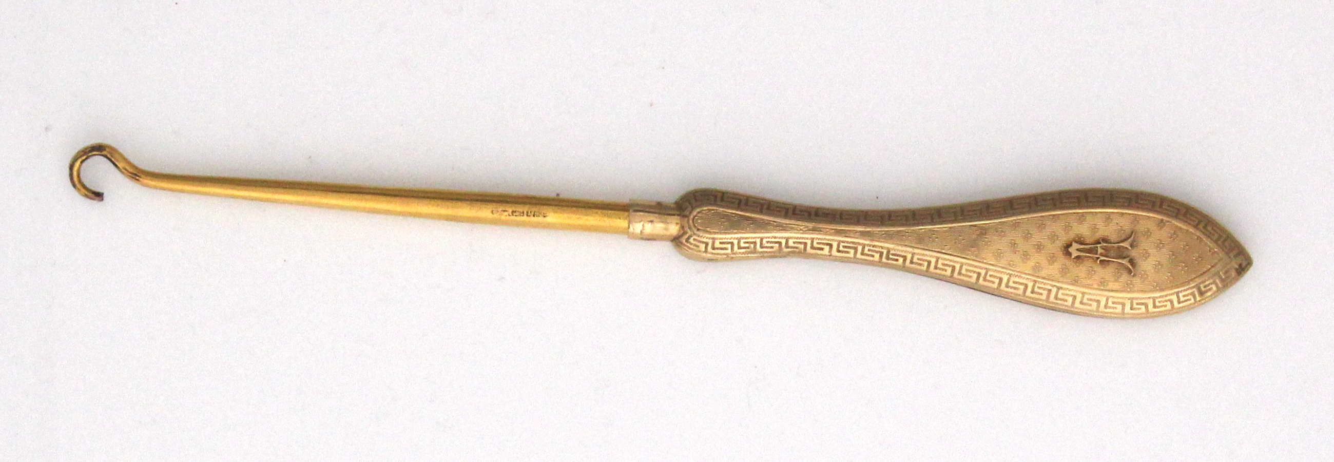 An antique 9ct yellow gold button hook by Mappin & Webb, the gold handle with finely engine turned