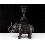 An oriental cast metal statue of an elephant carrying a pedestal on its back, suitable for