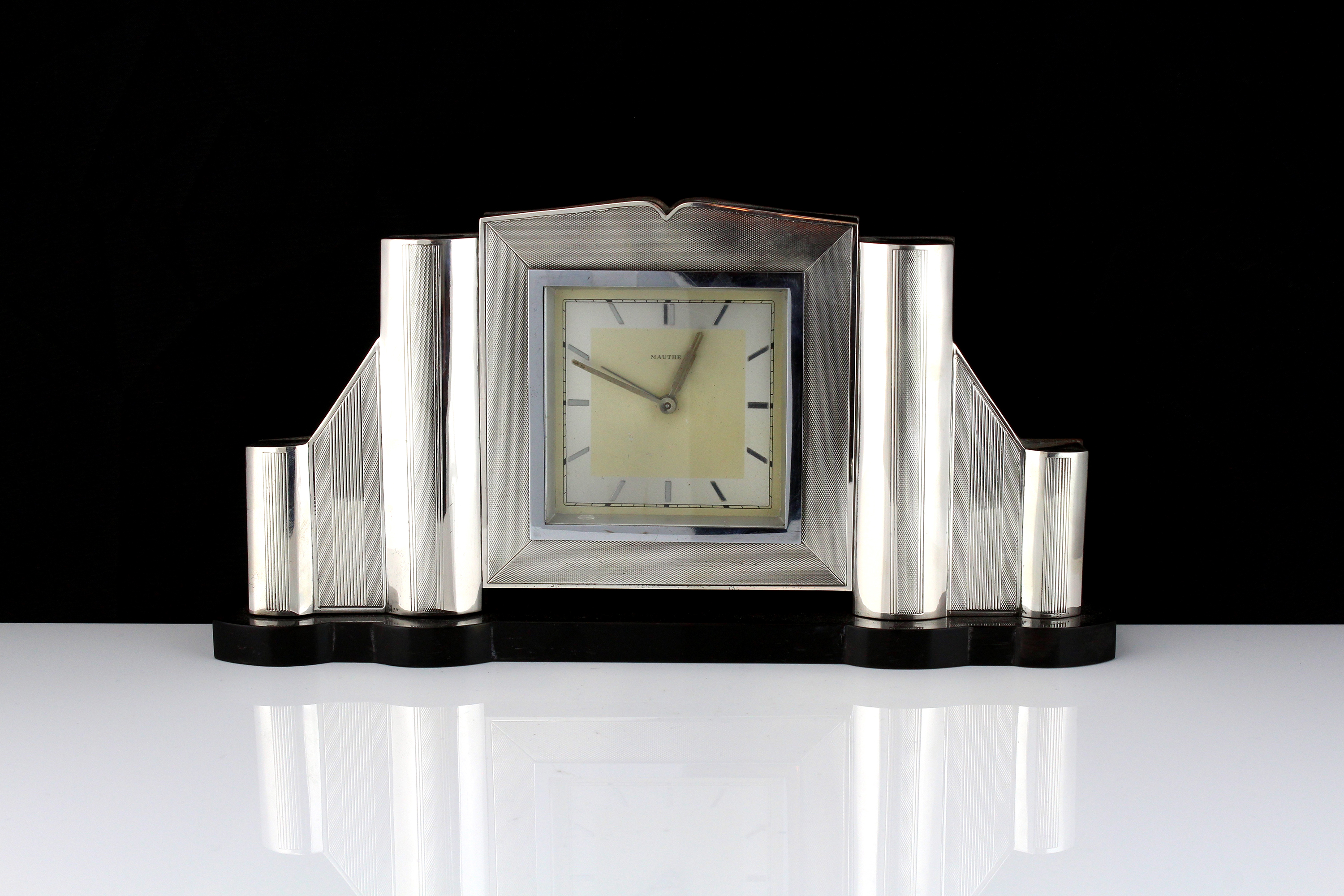 An Art Deco style German Silver mantel clock the geometric body with panels of engine turned