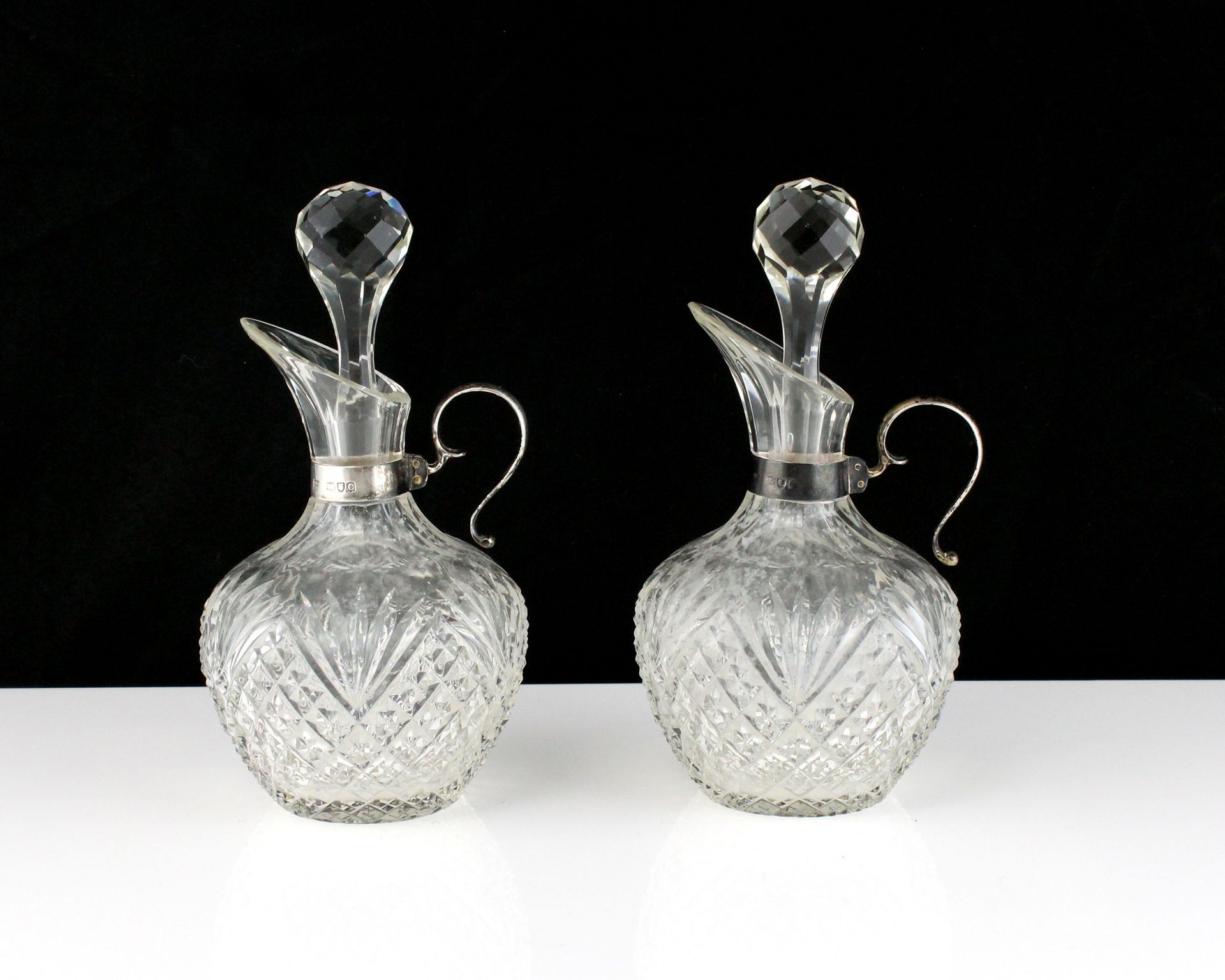 A pair of antique Victorian Sterling Silver mounted oil and vinegar jugs by the Betjemann