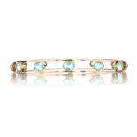 AN ANTIQUE AQUAMARINE SLAVE BANGLE, CIRCA 1920 designed as a single row of twelve oval cut