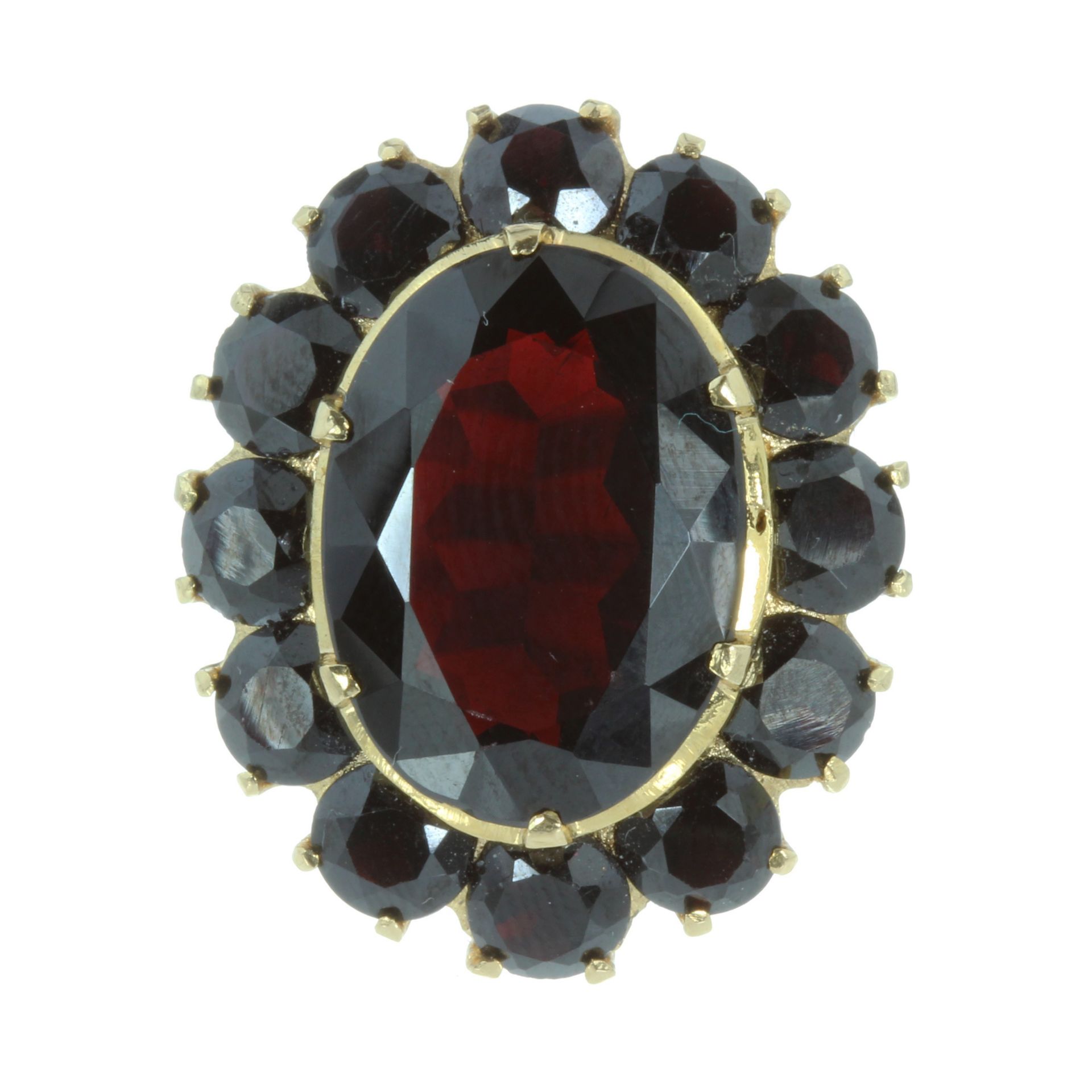 A GARNET CLUSTER COCKTAIL RING set with a large oval cut garnet surrounded by a cluster of twelve