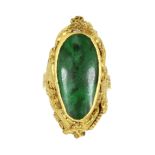 A CHINESE JADE DRAGON RING set with a large cabochon cut piece of jade in a rubover mount,