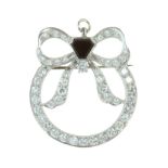 AN ONYX AND DIAMOND BOW BROOCH designed as a ribbon and bow jewelled with round cut diamonds, set