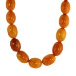 AN ANTIQUE NATURAL AMBER BEAD NECKLACE designed as a single row of twenty one graduated oval