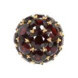 A GARNET BOMBE DRESS RING designed as a blackberry, set with nineteen variously sized round cut