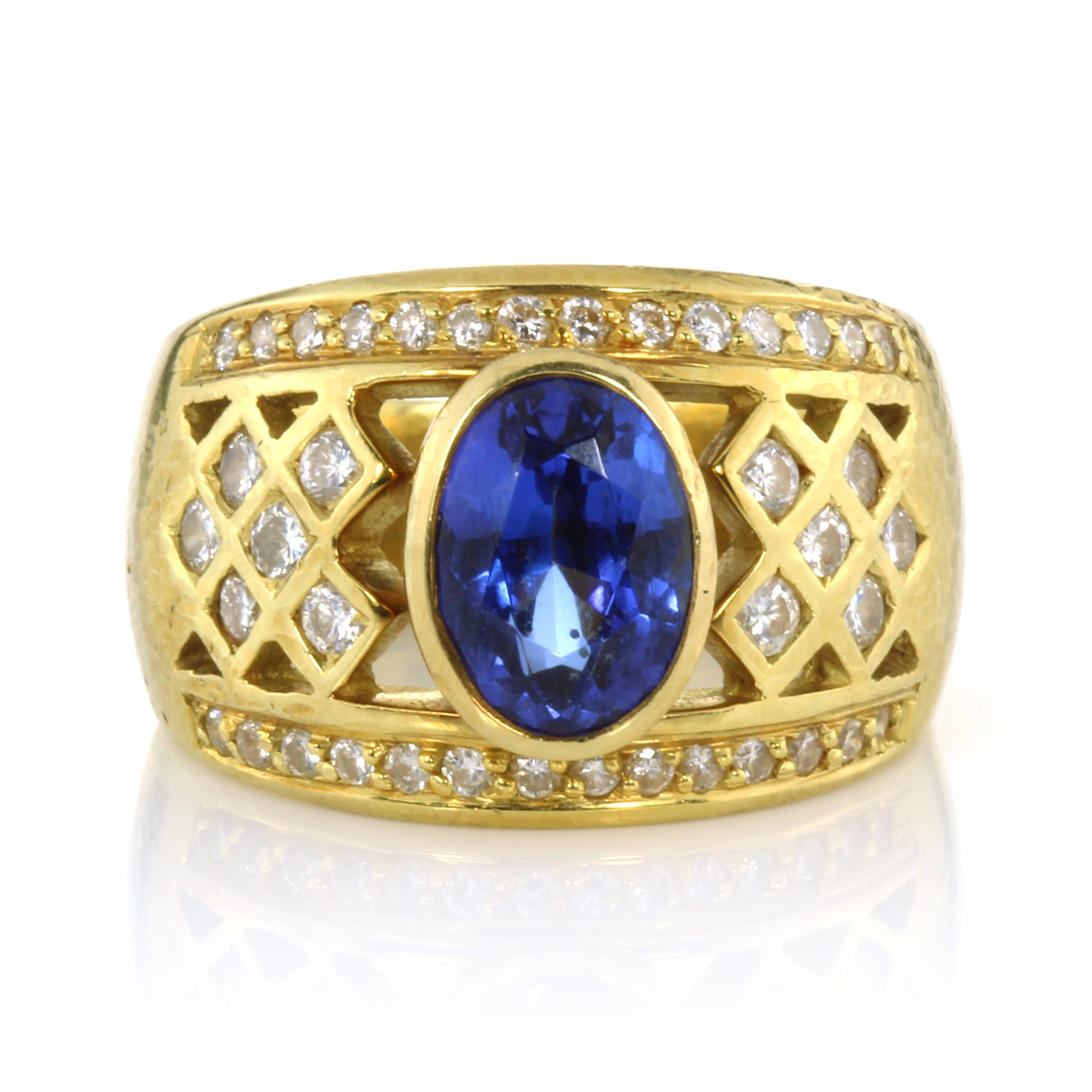 A TANZANITE DRESS RING set with an oval cut tanzanite of 2.61 carats with a jewelled diamond