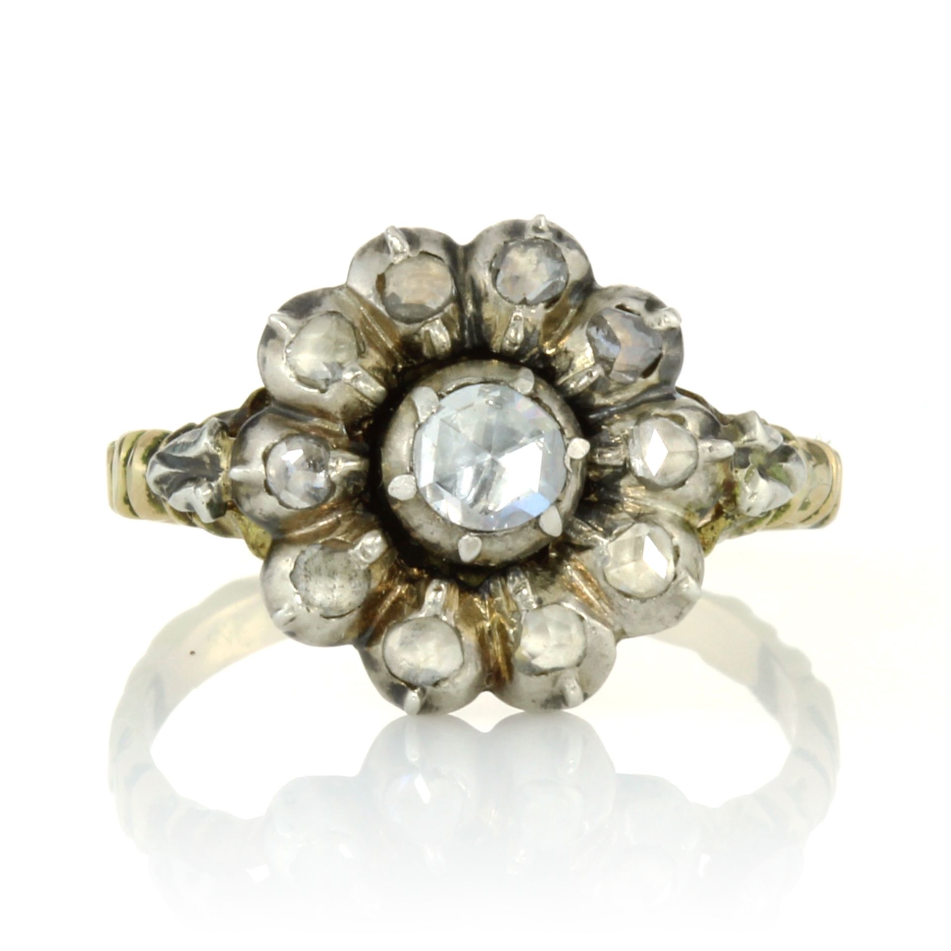 AN ANTIQUE DIAMOND CLUSTER DRESS RING set with a central rose cut diamond encircled by border of ten