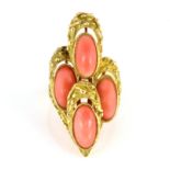 A VINTAGE CORAL COCKTAIL RING set with four elongated oval coral cabochons within textured