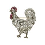 ***** WITHDRAWN ***** A DIAMOND AND RUBY COCKEREL BROOCH designed as a rooster set with round and
