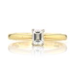 A 0.32 CARAT SOLITAIRE DIAMOND RING set with a single emerald cut diamond of 0.32 carats, on a