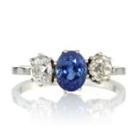 AN ANTIQUE SAPPHIRE AND DIAMOND THREE STONE RING set with a central blue sapphire of 1.38 carats