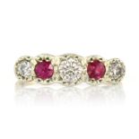 AN DIAMOND AND RUBY FIVE STONE RING set with five alternating, graduated round cut diamonds and