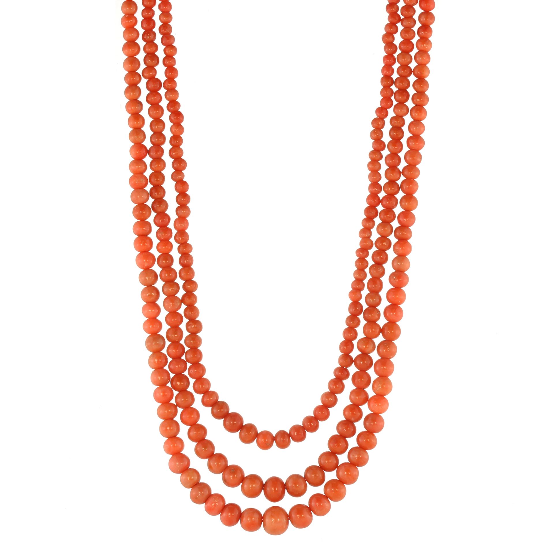 AN ANTIQUE THREE STRAND CORAL BEAD NECKLACE comprising three rows of graduated coral beads up to 8.