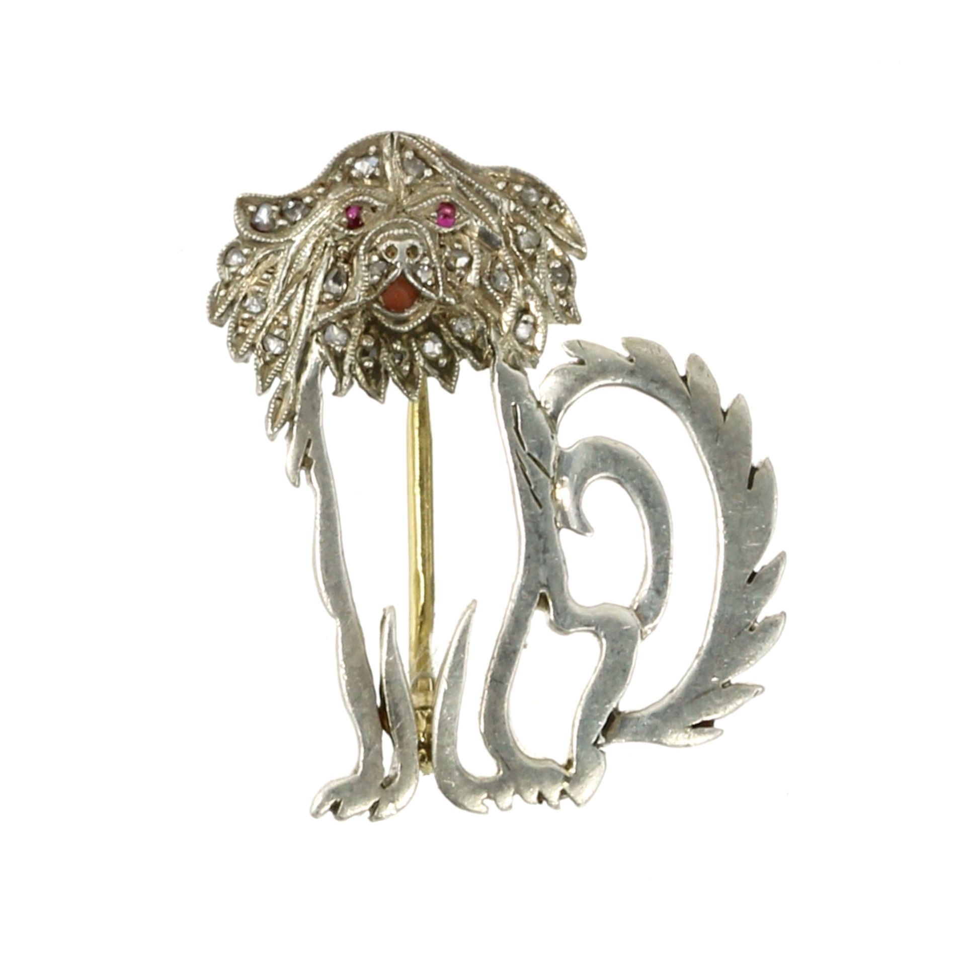 A RUBY AND DIAMOND DOG BROOCH modeled as a seated dog, its body outlined and its face jewelled