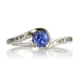 A SAPPHIRE AND DIAMOND DRESS RING set with a central blue sapphire in a twisted, crossover style