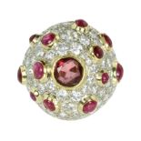 A GARNET, RUBY AND DIAMOND COCKTAIL RING of bombe form set with a central round cut garnet,