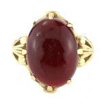 A GARNET DRESS RING set with a large oval cabochon garnet of 17.91 carats with scrolling shoulders