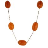 AN ANTIQUE NATURAL AMBER BEAD LONGCHAIN NECKLACE designed as a long white metal chain jewelled