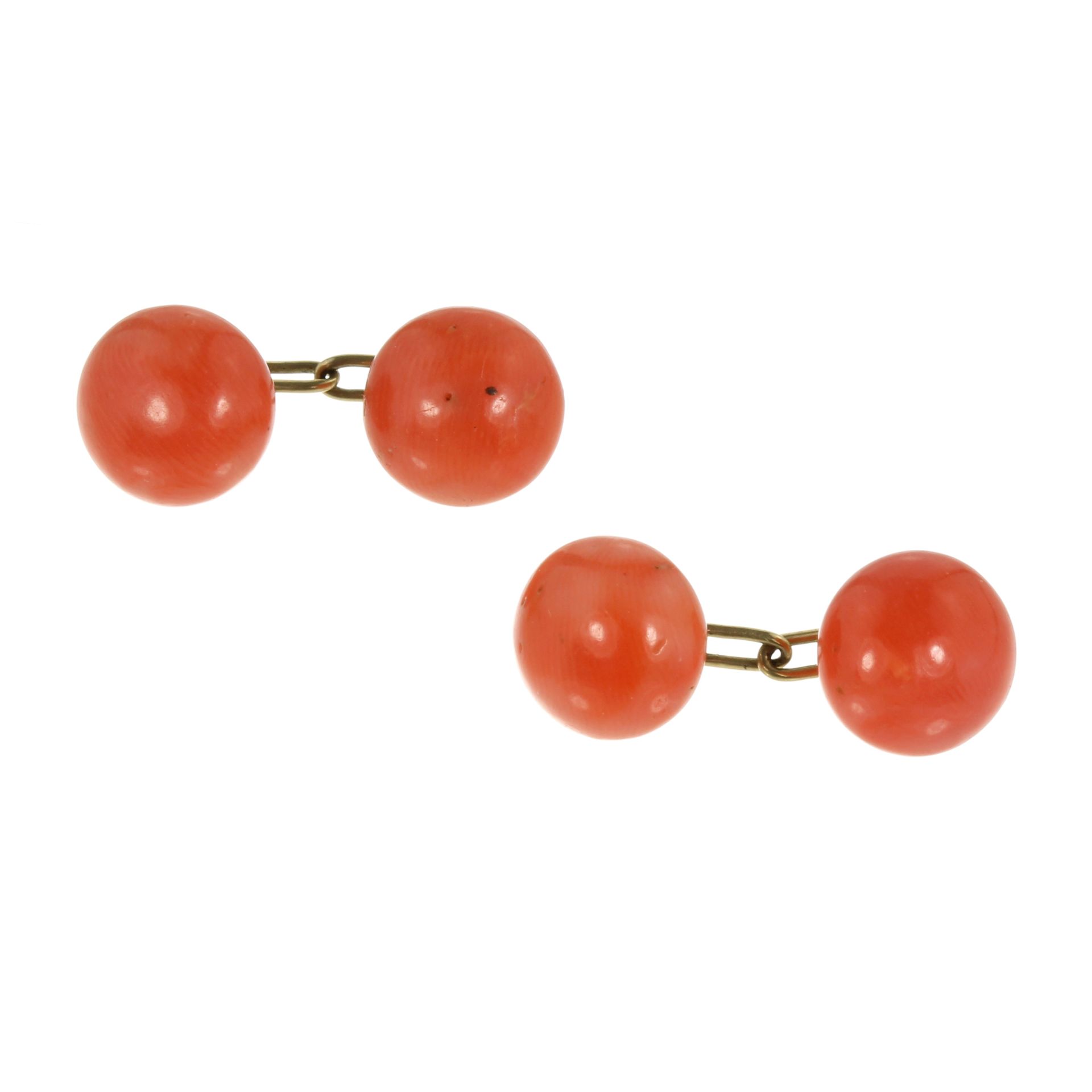 A PAIR OF ANTIQUE CORAL BEAD CUFFLINKS each comprising two polished coral beads of 10-11mm in