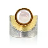 A PEARL AND DIAMOND RING, ATELIER ZOBEL set with a large, bouton pearl to a thick two-colour band,