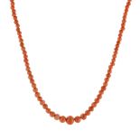 AN ANTIQUE CORAL BEAD NECKLACE comprising a single strand of graduated polished coral beads up to