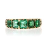 AN ANTIQUE EMERALD FIVE STONE RING, CIRCA 1910 set with five graduated emerald cut emeralds within a