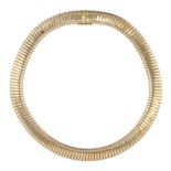 A GOLD CHOKER NECKLACE in yellow gold designed as a single extending link snake style chain of
