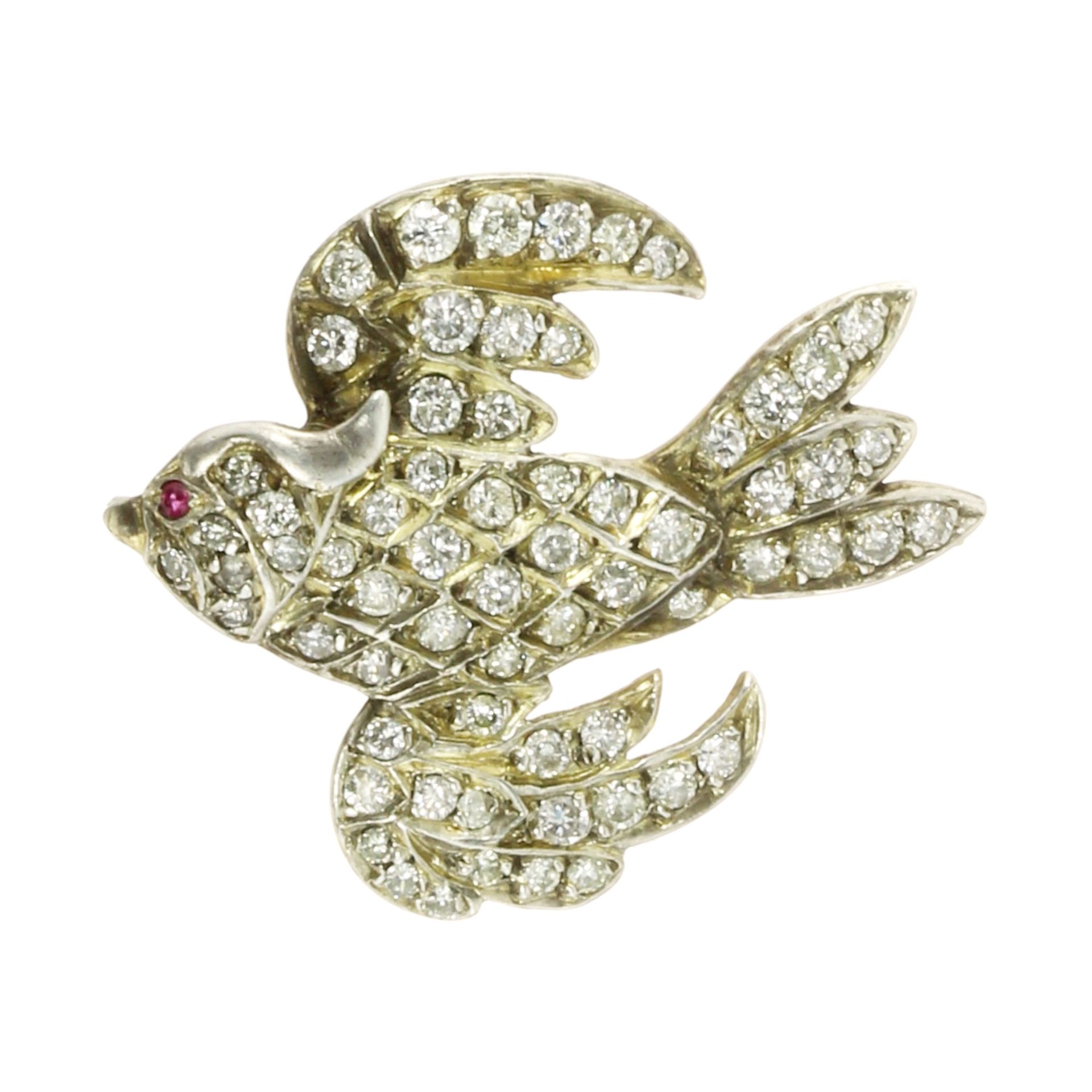 A JEWELLED RUBY AND DIAMOND BIRD BROOCH in yellow gold modeled as a bird in flight, jewelled all