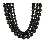 AN ANTIQUE JET BEAD NECKLACE comprising five rows of graduated polished and carved jet beads with