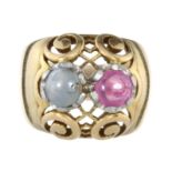 A PINK AND GREY SAPPHIRE DRESS RING in 18ct yellow gold set with two round cabochon sapphires, one