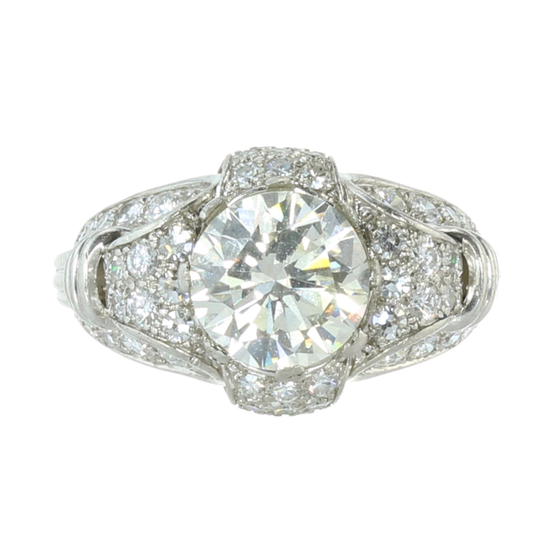 A DIAMOND COCKTAIL RING in platinum set with a central round cut diamond of 3.52 carats within a