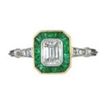 AN ANTIQUE ART DECO DIAMOND AND EMERALD RING in white gold or platinum set with a central emerald