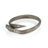 AN ANTIQUE SNAKE BRACELET / BANGLE in silver, designed as the body of a serpent coiled around