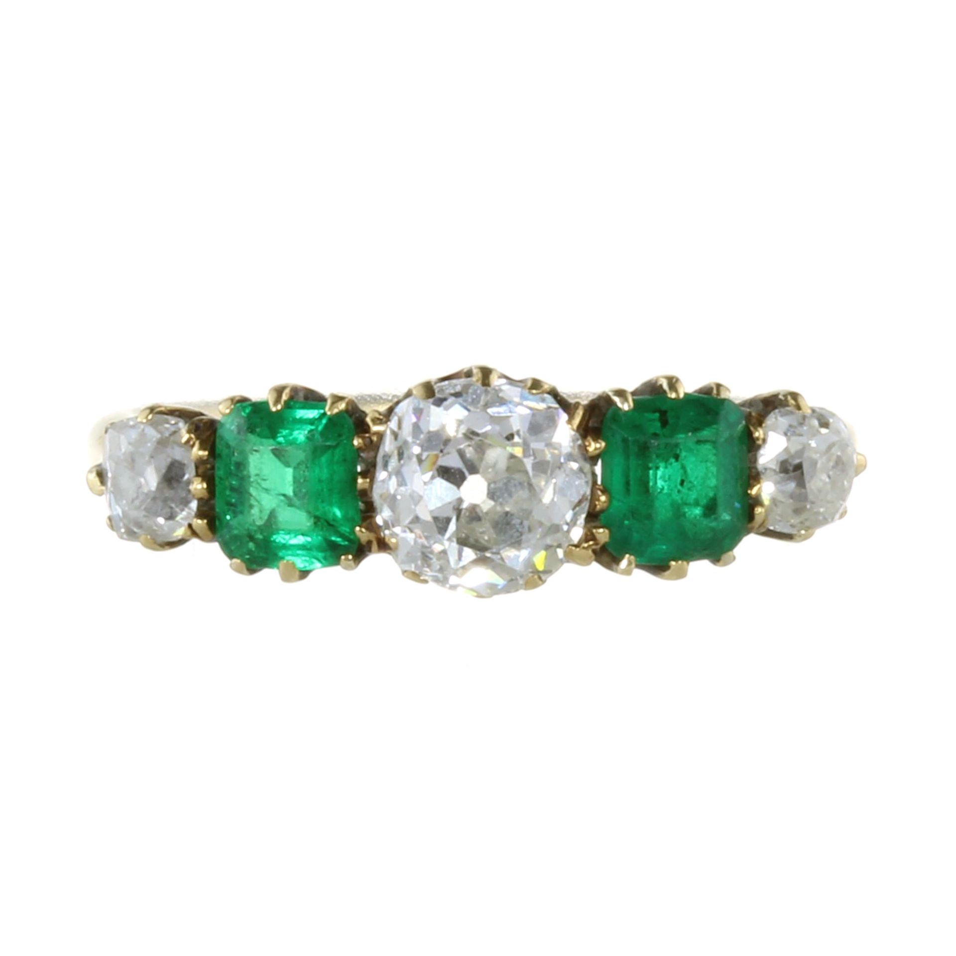 AN ANTIQUE DIAMOND AND EMERALD FIVE STONE RING in 18ct yellow gold set with a row of five